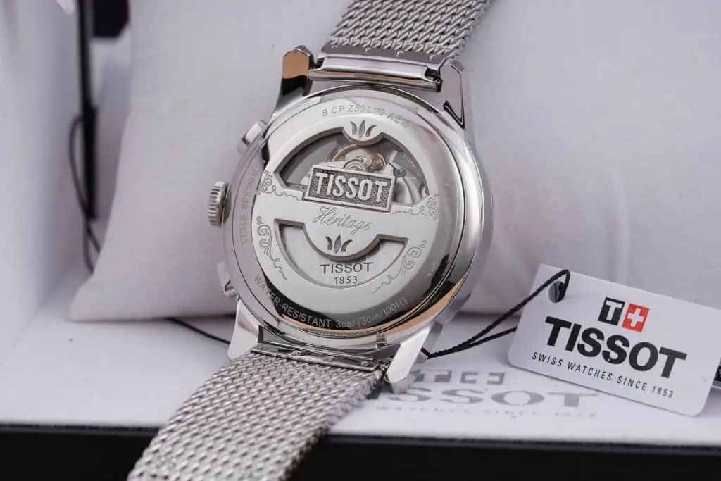The caseback of a Tissot Heritage. Displayed are the water resistance numbers and the materials the watch is made with.